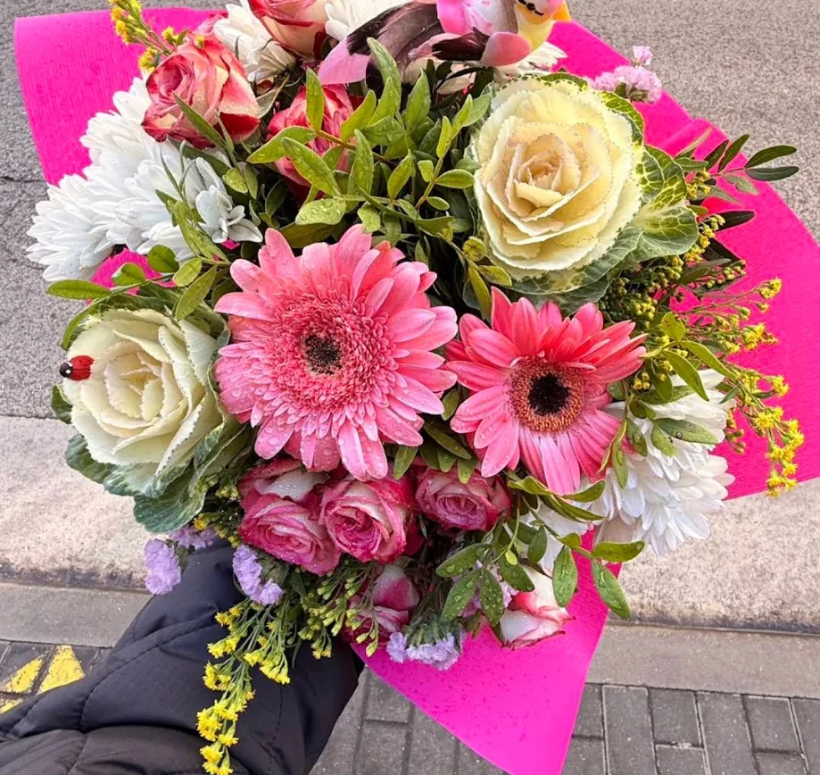 Ramo con gerberas rosas, kale ornamental y flor amarilla en papel rosa